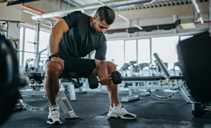 Man doing seated curling dumbbell exercises in exercise bench