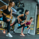 Woman doing kettle-bell weight strengthen exercises during a gym class