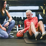 Elder man doing strengthen core exercises with medical ball